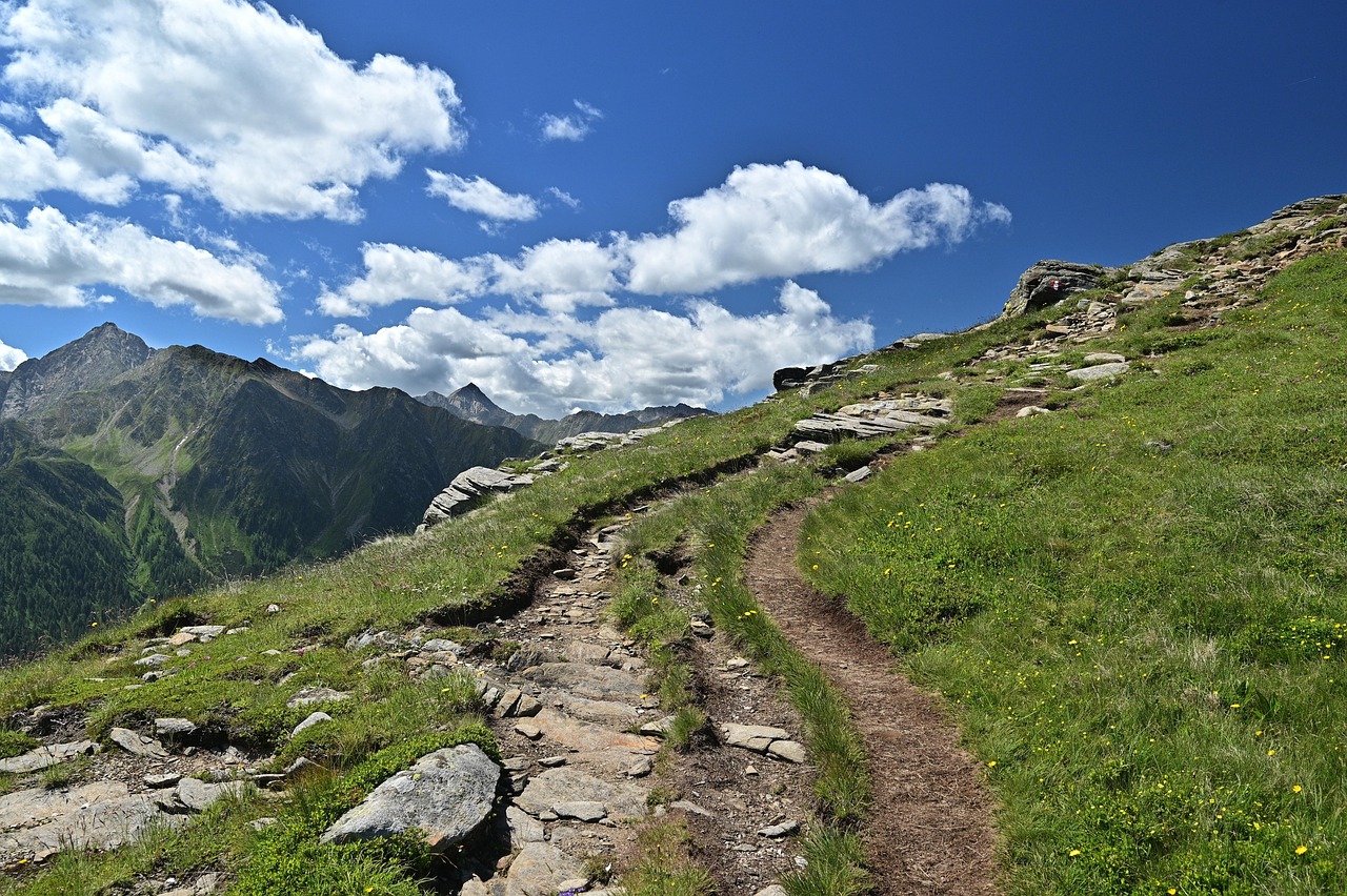 Bergpad dat de weg van het midden verbeeldt, kronkelend tussen rotsen en bergweide